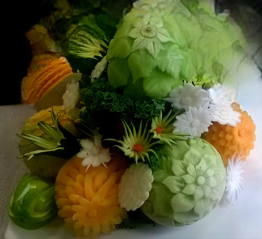 a centerpiece display of cantaloupe and honeydew cut into shapes of flowers.